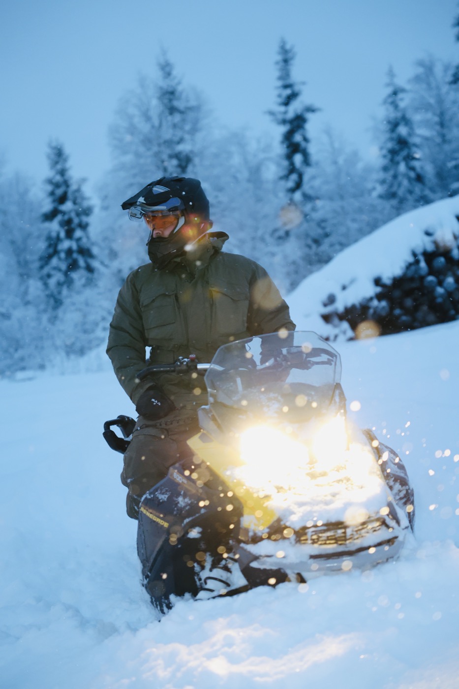 Single rider on a snowmobile among snow-covered trees
